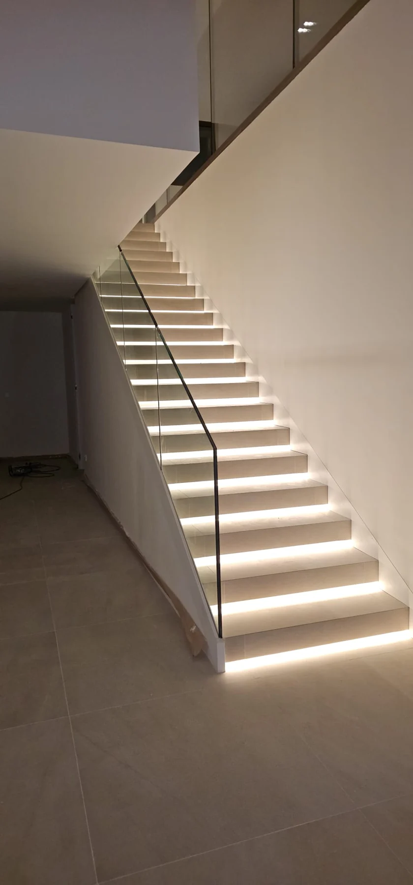Escalera con iluminación cálida integrada bajo cada peldaño.