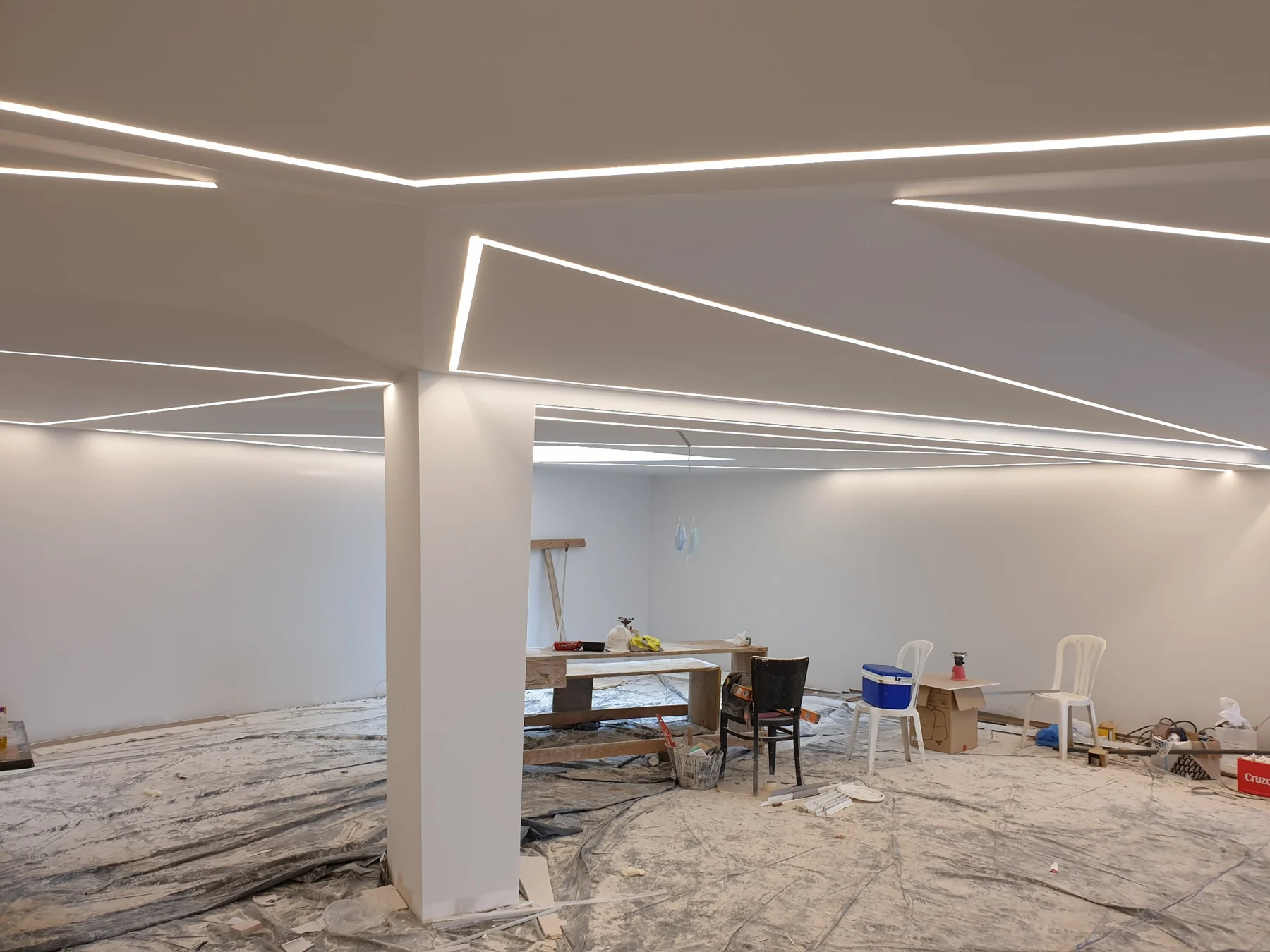 Líneas LED integradas en el techo durante la fase de acabado de una instalación.