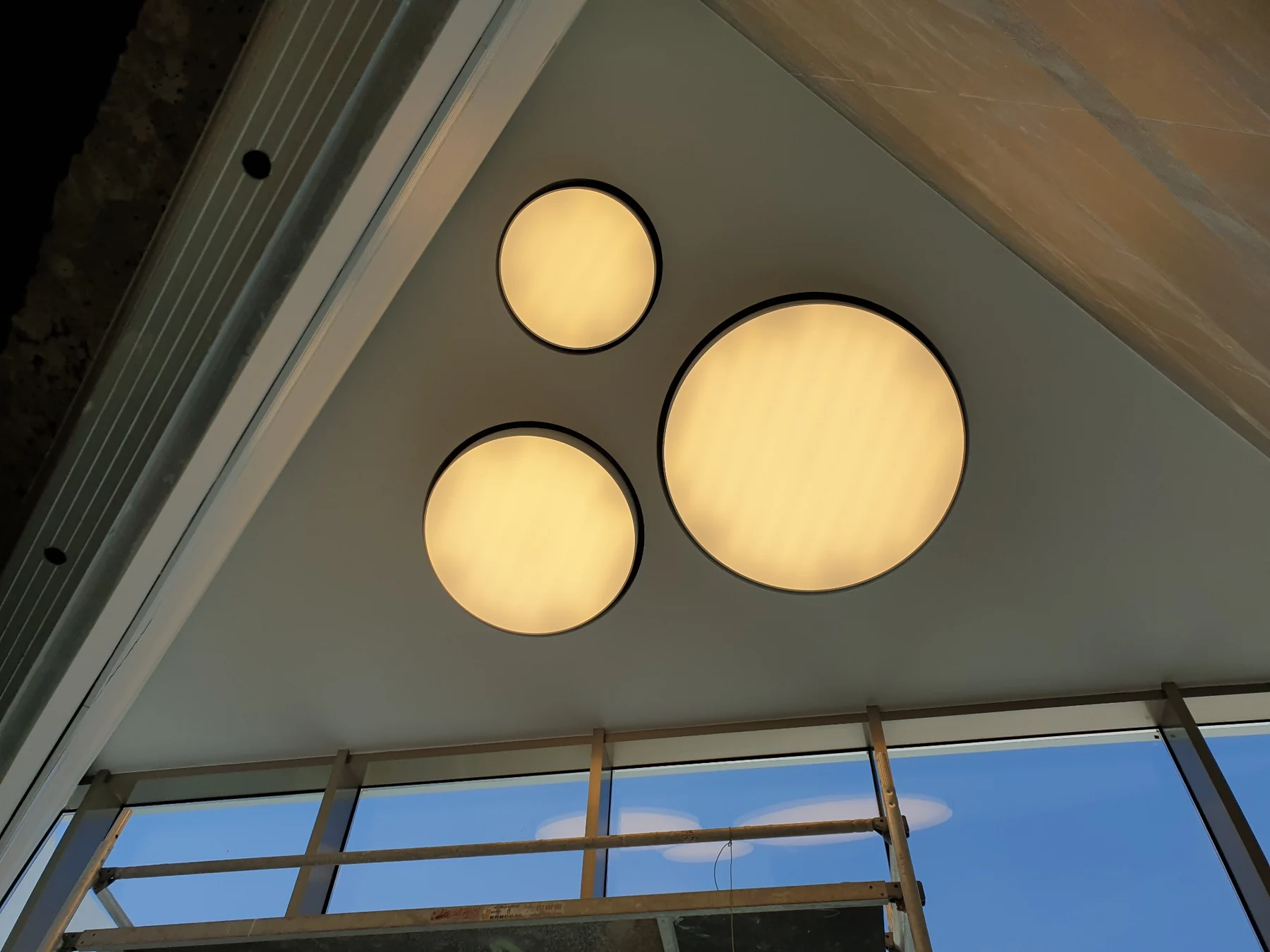Conjunto de luminarias circulares suspendidas a diferentes alturas.